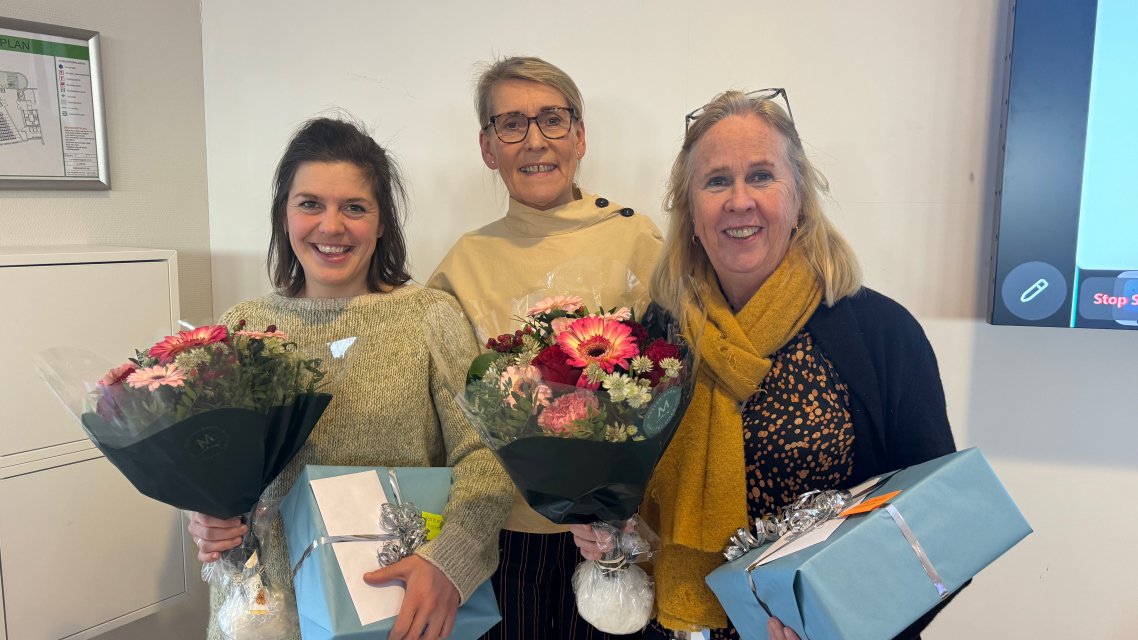 Karoline Skedsmo og Unni Jenssen med blomster og gaver, sammen med rektor Hulda Gunnlaugsdottir i midten